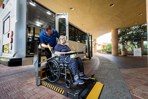 helping client in wheelchair off bus